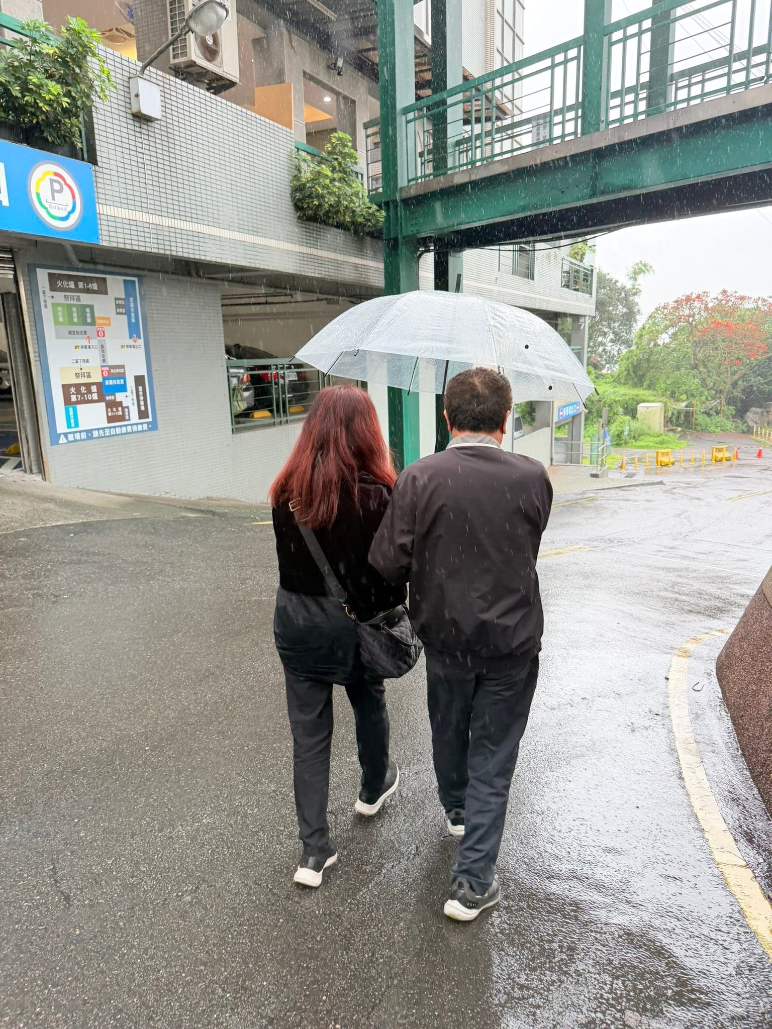 下著雨的路上，家人撐著透明雨傘並肩走著