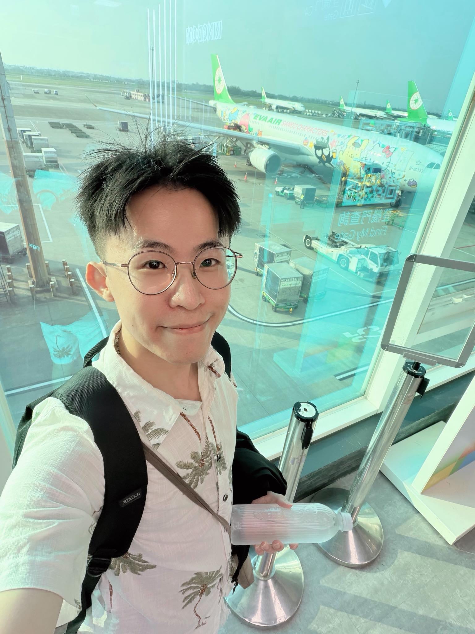我背著背包在機場登機口落地窗前自拍，準備飛往宿霧