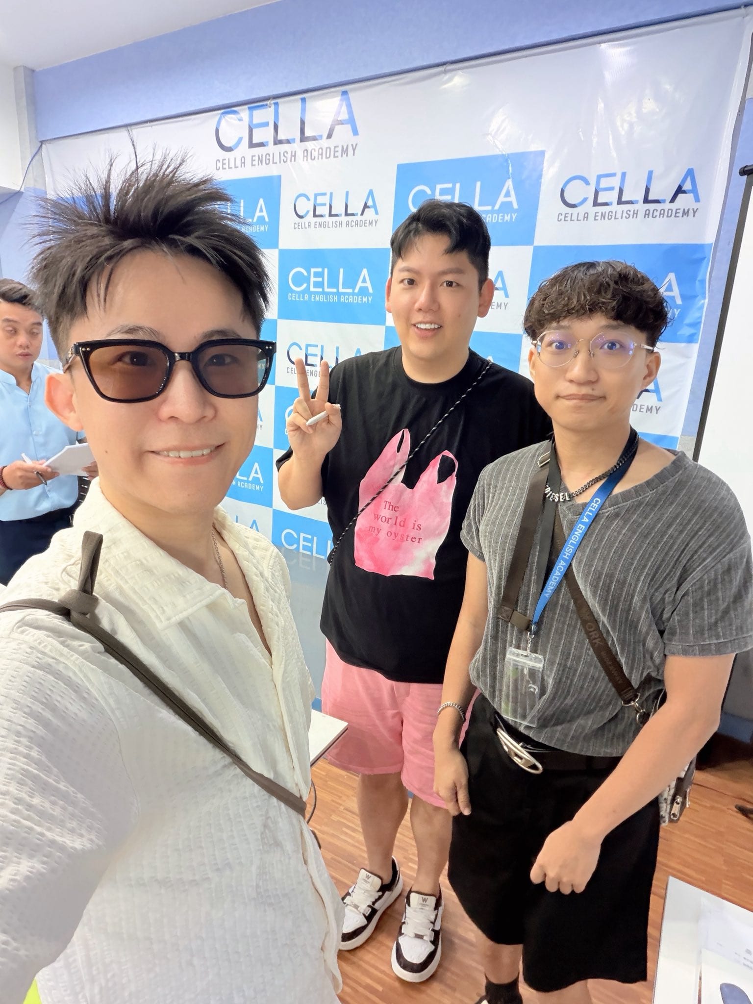 我和兩位同學在 CELLA 語言學校的背板前合照