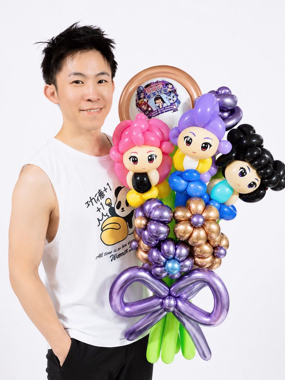 穿白色背心的柯男抱著獵魔女團氣球花束，花束後方的圓框裡放著客製角色圖卡