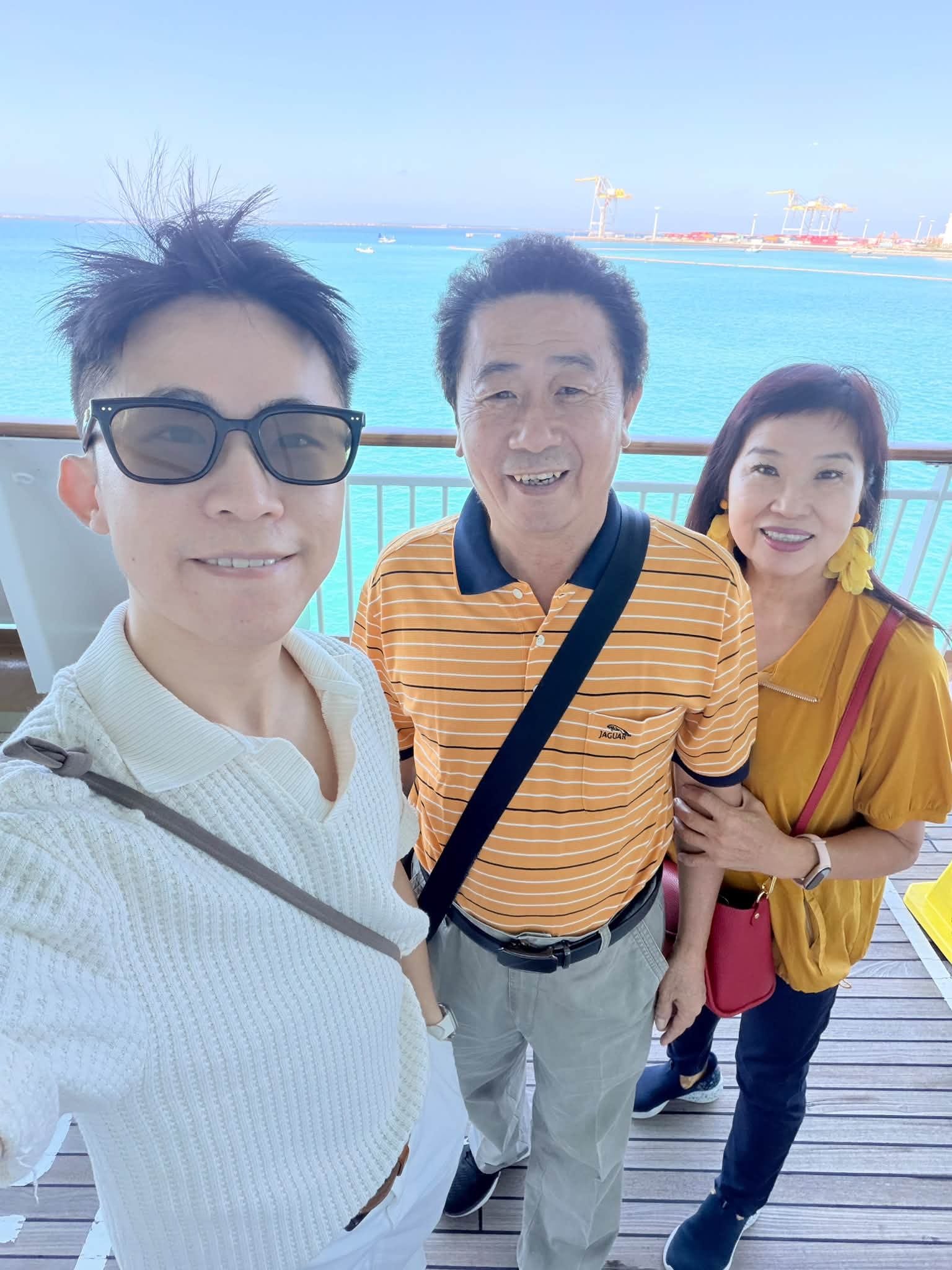 我和爸媽在郵輪甲板上自拍，背景是藍色海面