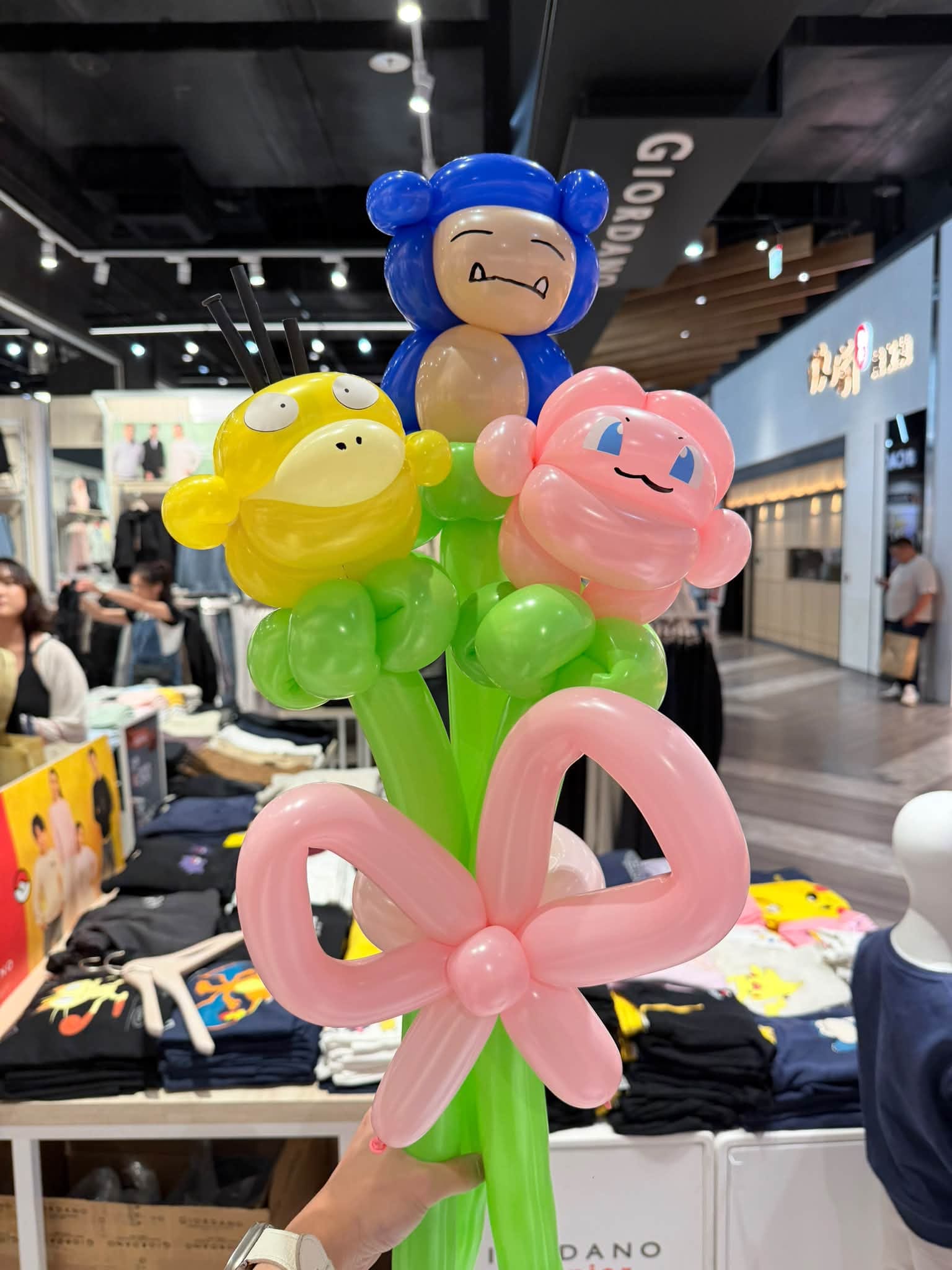 佐丹奴店內的寶可夢造型氣球花束,黃色可達鴨、藍色角色與粉紅色角色,下方綁粉紅色蝴蝶結