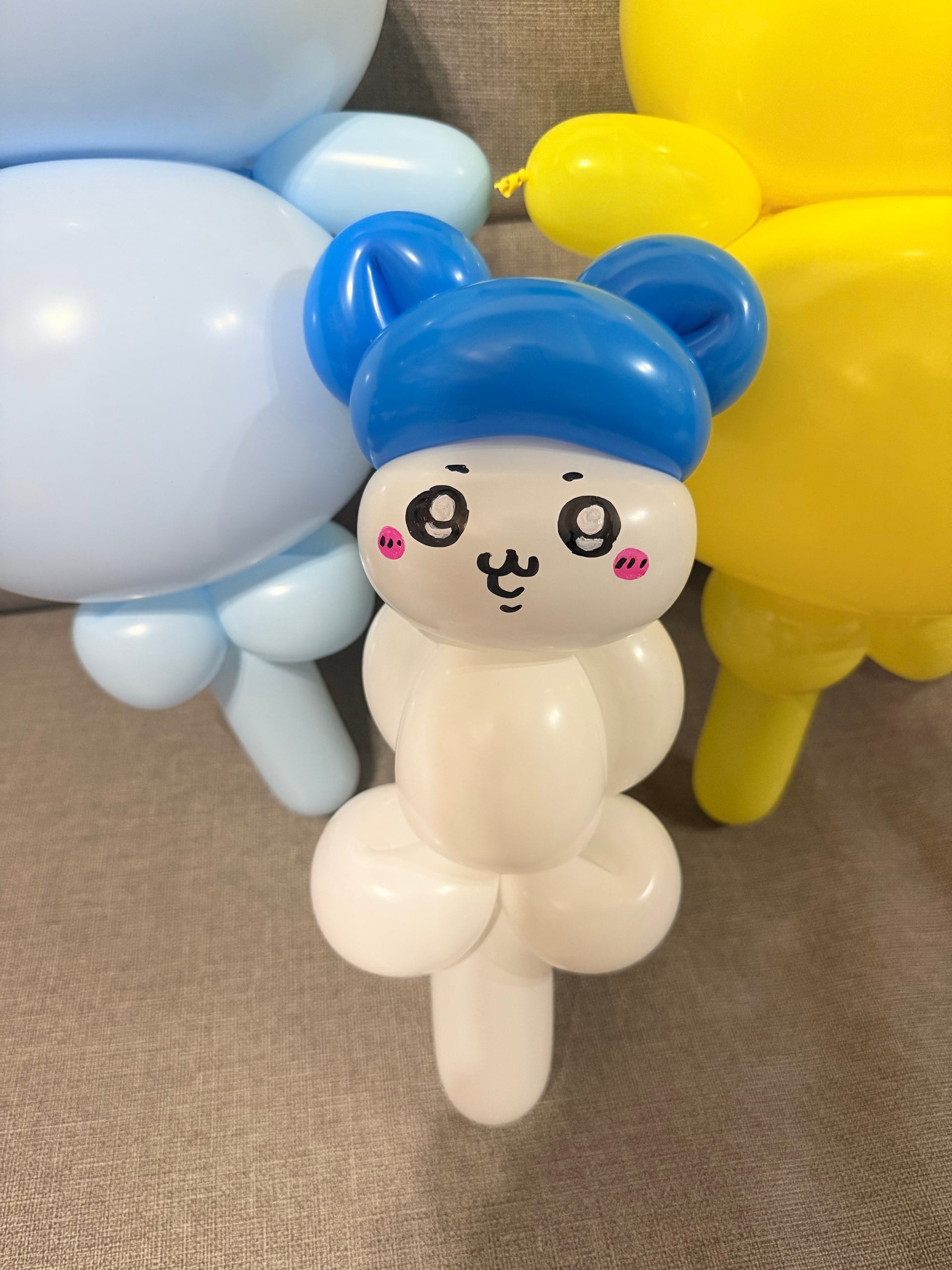 吉伊卡哇的小八造型氣球,戴著藍色帽子、臉頰粉紅的白色小動物