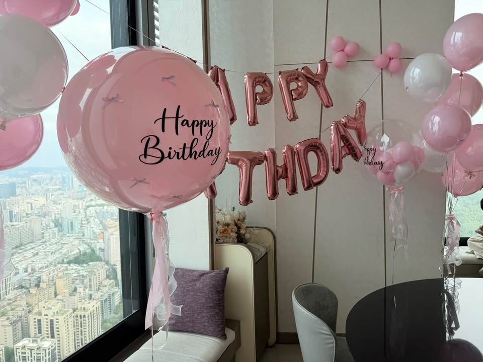 貼滿小蝴蝶結的粉色雙層大氣球，印黑色 Happy Birthday 草寫字，下方綁粉色緞帶